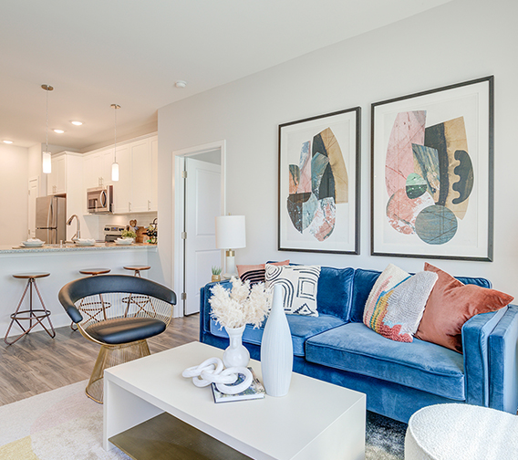 Living room with colorful rug, plush furniture, eclectic decor, and large window.