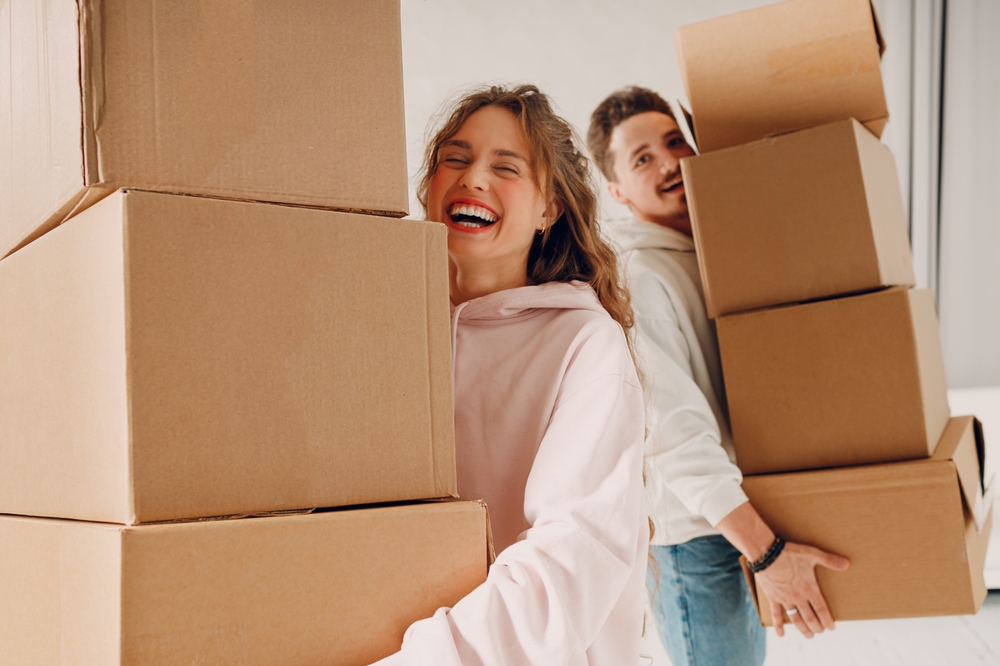 Happy,Young,Family,Couple,Man,And,Woman,Moving,With,Cardboard